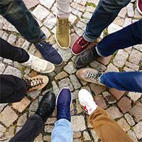 A group of people's legs and shoes pointing towards the center